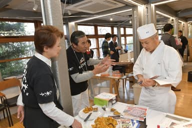 事業者と話し込む野崎シェフ