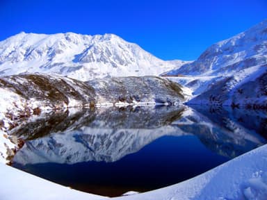 室堂平・みくりが池の湖面に鮮やかに映える、新雪の立山