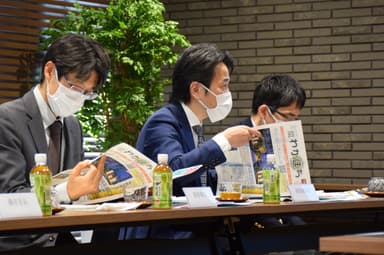 意見交換会でタウン誌『わがまち』の説明を受ける濱地副大臣(中央)(特別養護老人ホームユーカリゆうとの杜にて撮影)