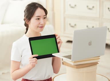 顧客はiPadで送られたテストカラーを顔に当て、その様子をPCで通信する