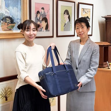 完成したスクールバッグを手にする山口 絵理子代表(左)と松井 真佐美校長(右) 写真＝Copyright 2025 MOTHERHOUSE Co.&#44;Ltd.