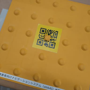 点字ブロックの真ん中に、ナビゲーションシステムの二次元コードが貼られています